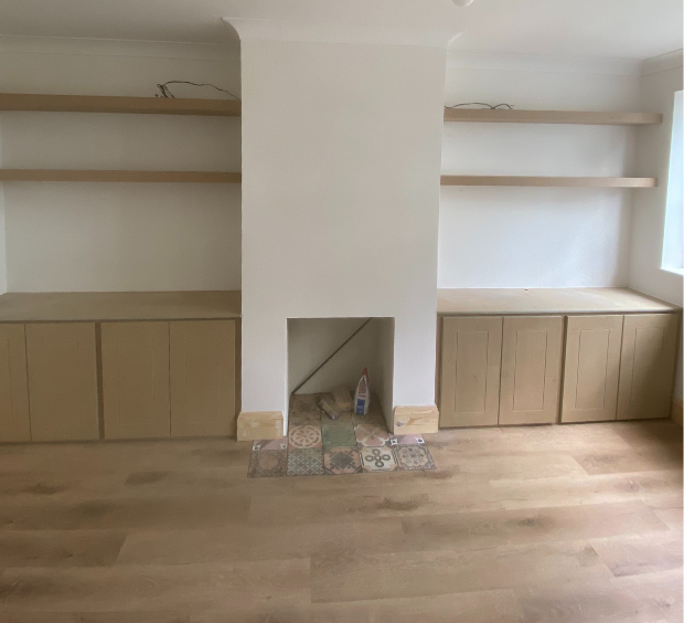 built in wooden cupboards either side of a fireplace