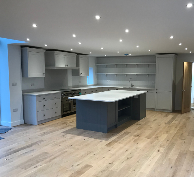finished light grey kitchen with dark grey island in middle